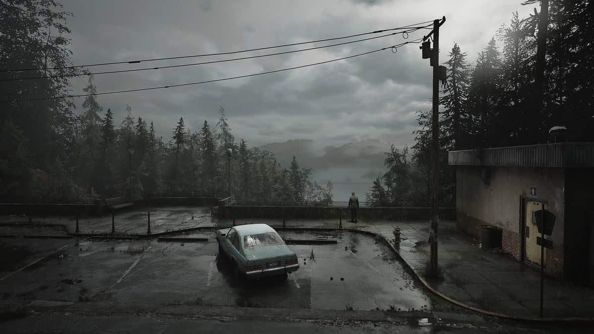 Parking mouillé surplombant un lac brumeux, voiture bleue à l'arrêt et forêt de sapins sous un ciel gris