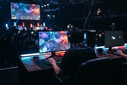 Joueur de dos concentré sur un match compétitif devant un grand écran, ambiance esport en salle