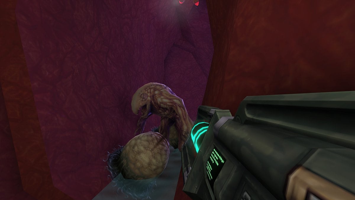 Capture de System Shock 2 remasterisé : une créature mutante près d'un œuf dans un couloir organique rougeâtre.
