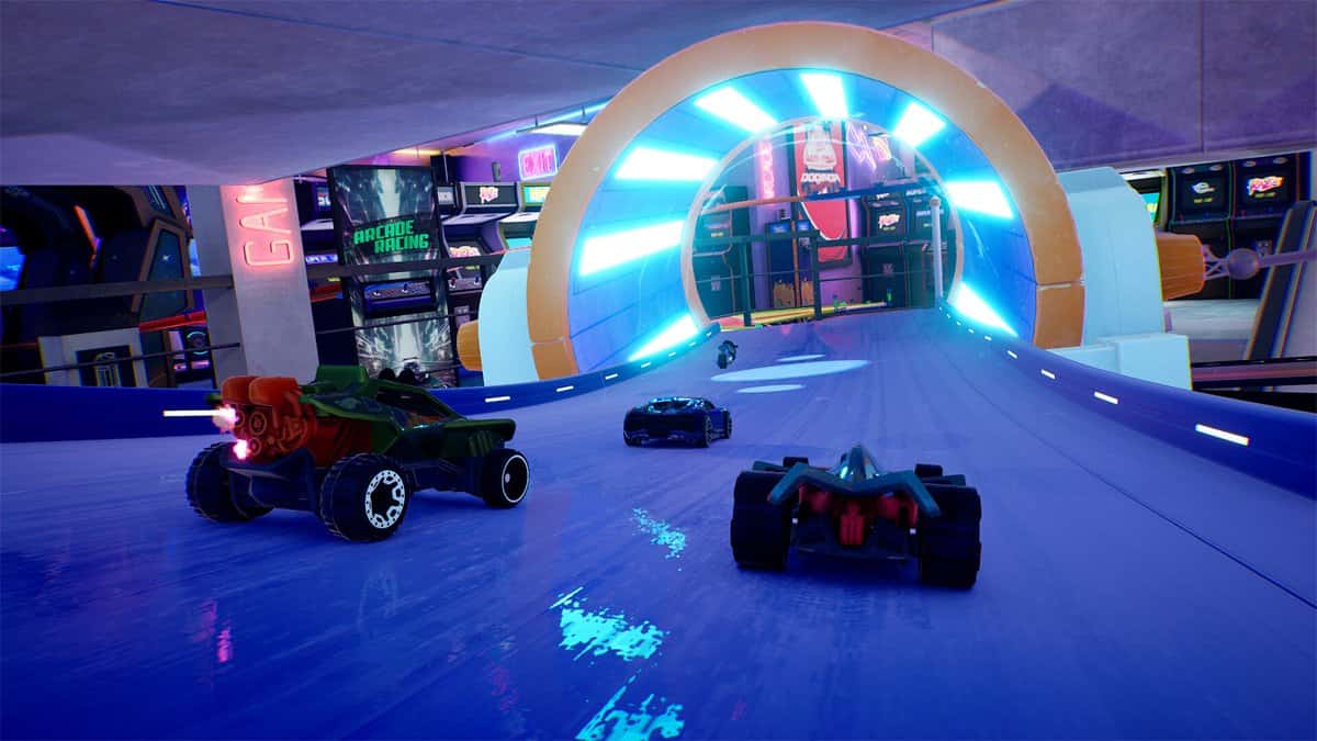 Trois véhicules foncent vers un anneau lumineux bleu sur une piste au milieu de bornes d'arcade