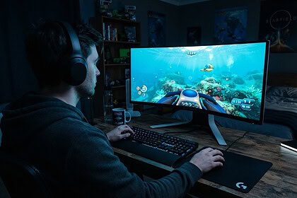 Joueur casqué devant un écran incurvé montrant un récif sous-marin turquoise et un petit sous-marin jaune