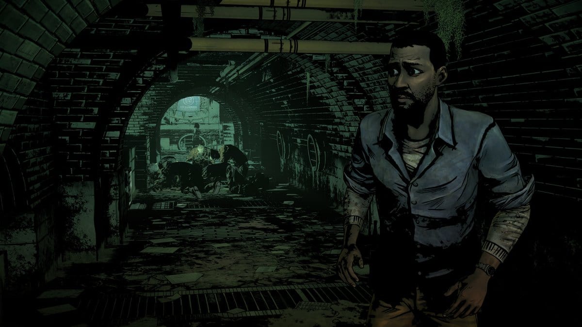Capture de The Walking Dead : Lee, inquiet, dans un tunnel en briques avec des rôdeurs en arrière-plan
