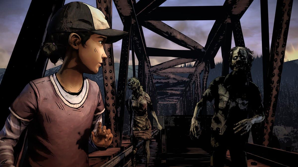 Capture de The Walking Dead : Clémentine, casquette sur la tête, se retourne sur un pont métallique face à deux rôdeurs